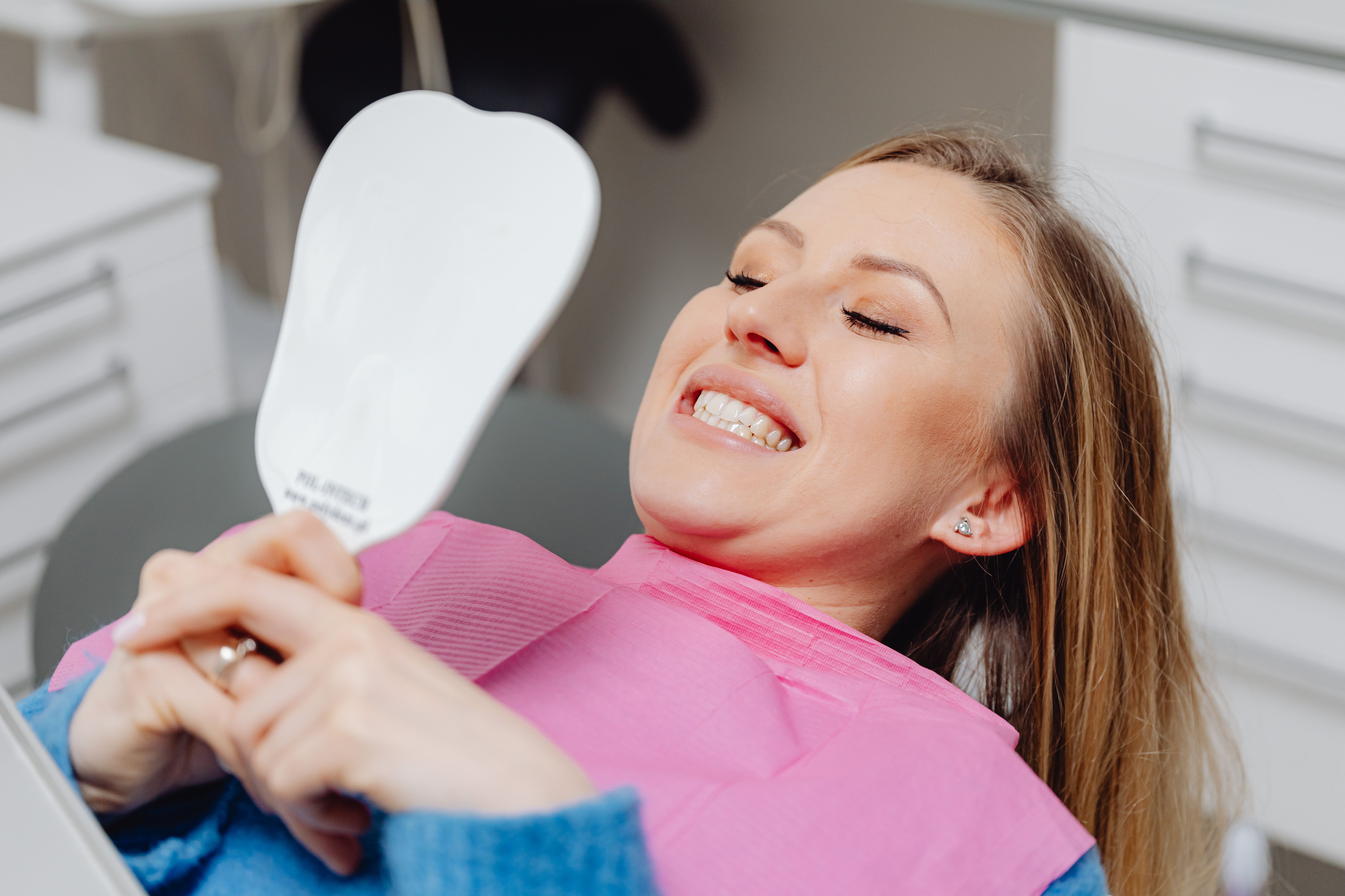 A smiling patient looking in a mirror