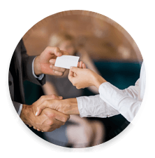 Two people shaking hands and exchanging business cards