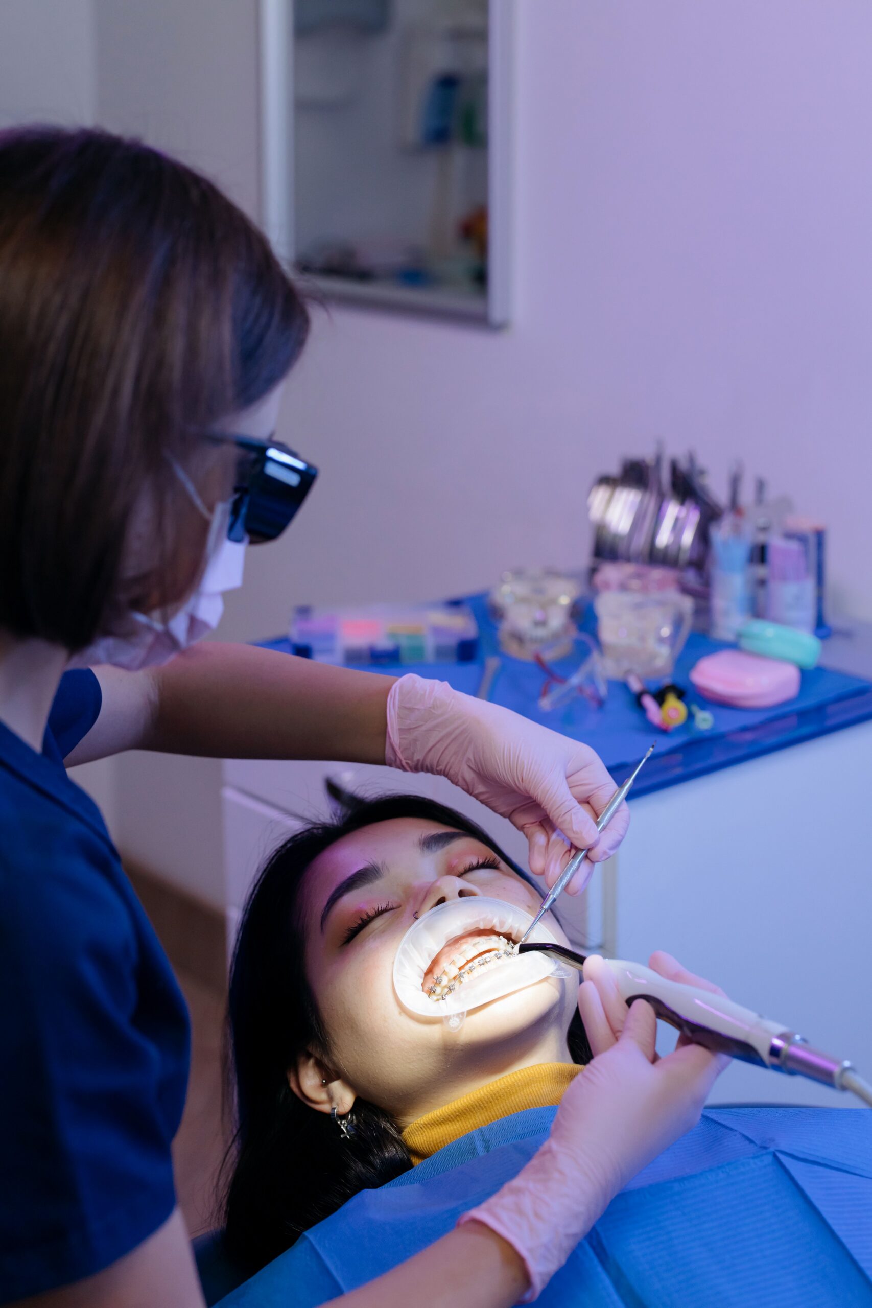 A smiling patient comparing tooth shades with a dental professional
