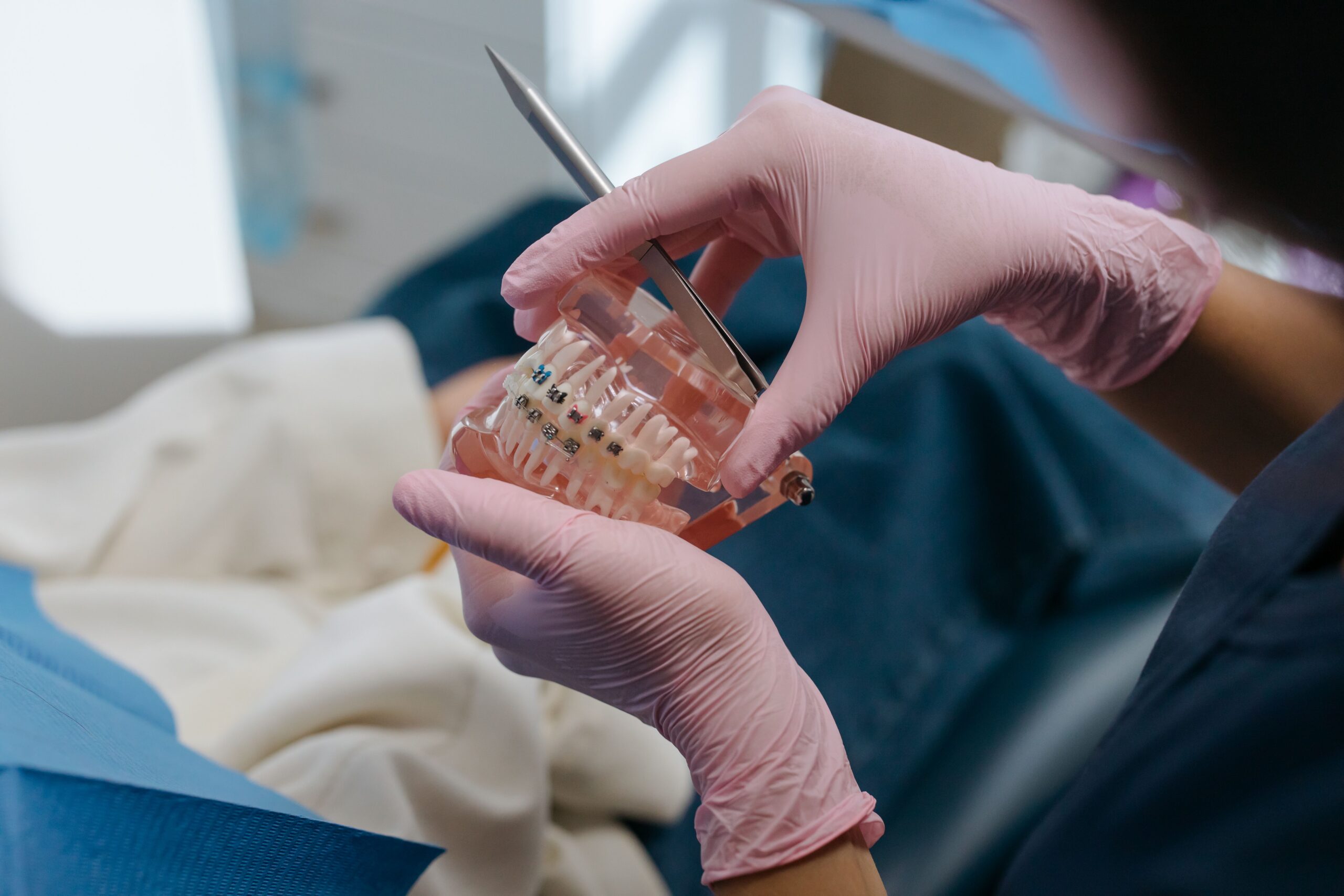 A close-up of a smiling patient holding a clear aligner