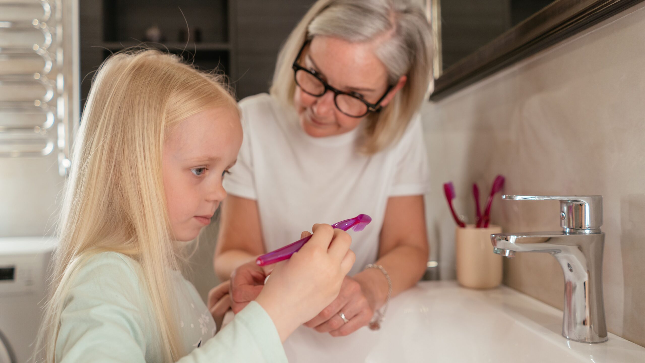 A dental professional showing a tooth model to a young patient