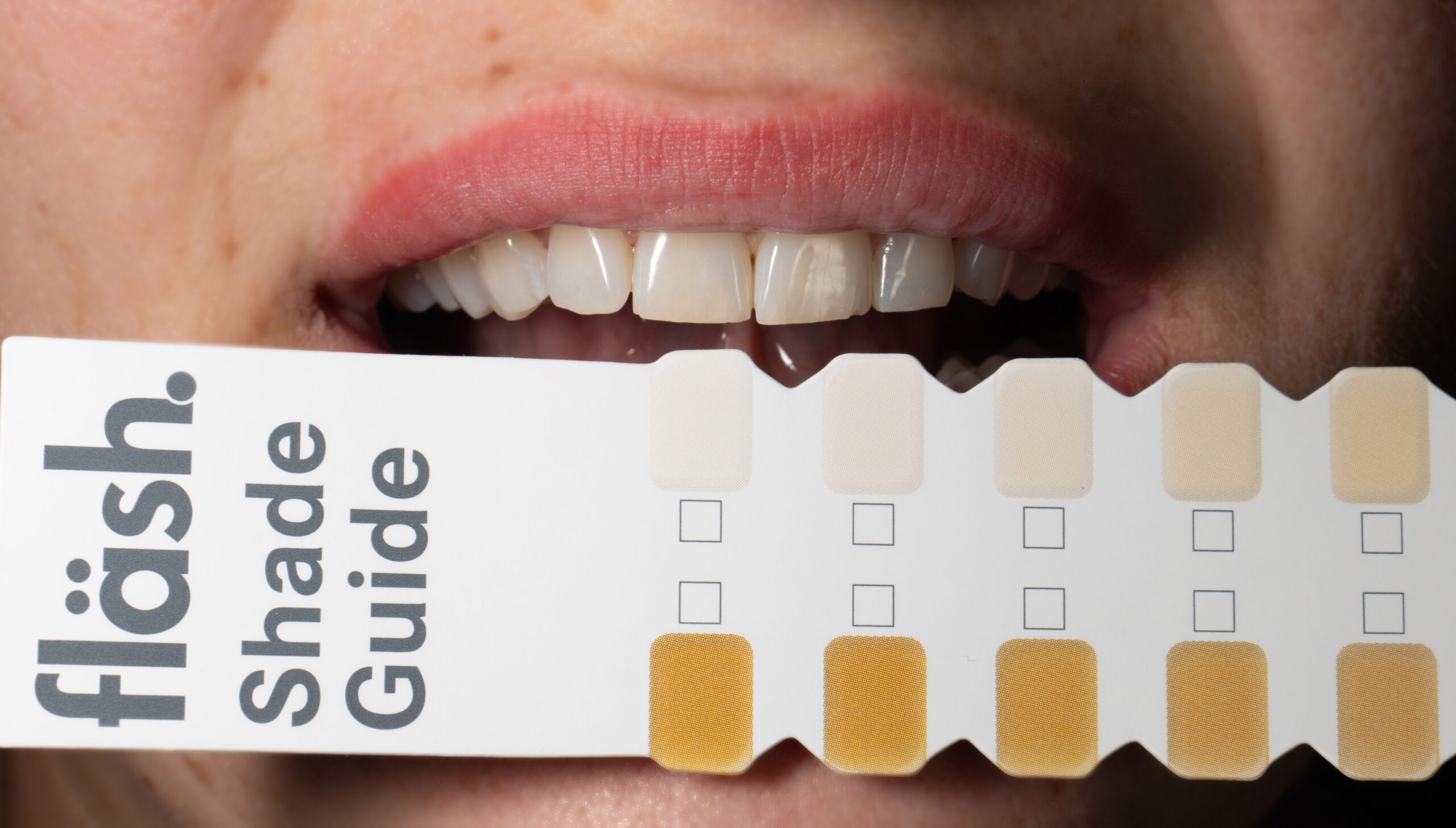 A patient smiling while looking into a mirror after dental care
