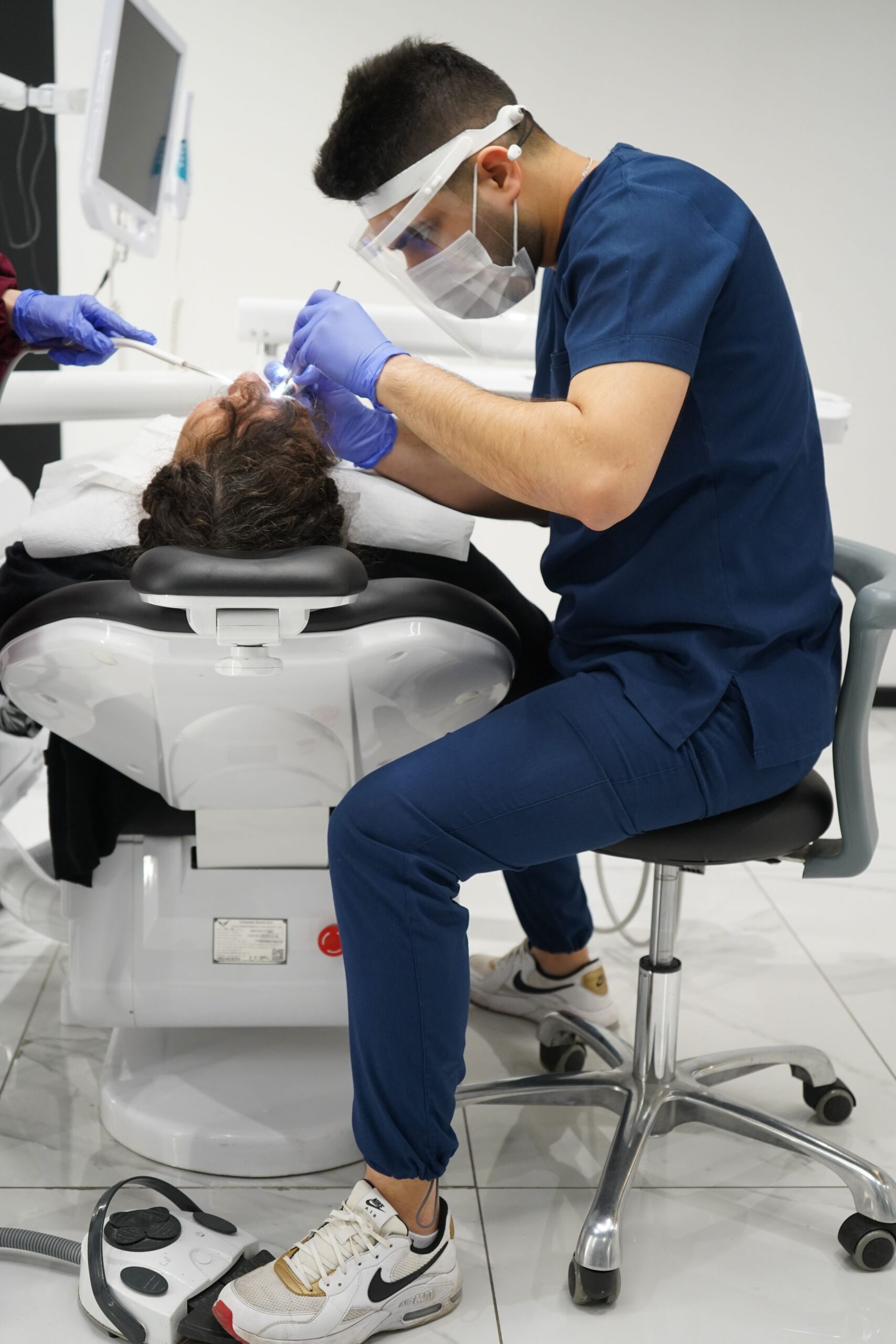 A smiling patient sharing a high five with a dental professional