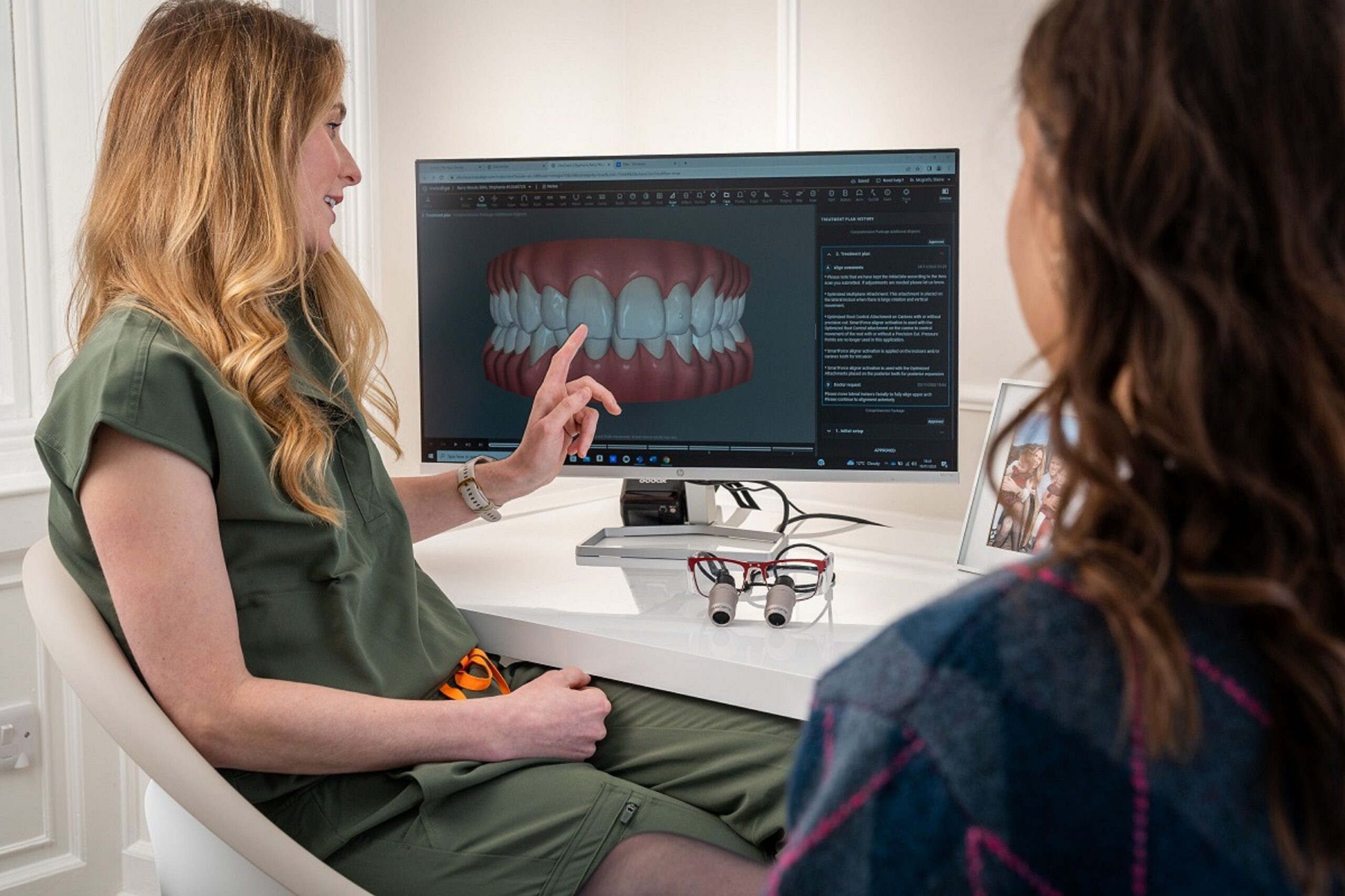 A patient smiling while looking into a mirror after dental care